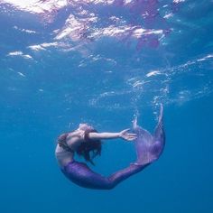 a woman is swimming in the blue water