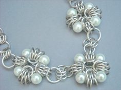 a silver bracelet with white pearls on it