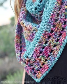 a woman wearing a multicolored crocheted scarf