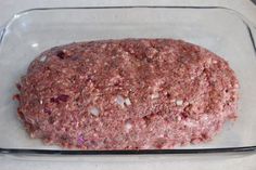 a square glass dish filled with ground meat