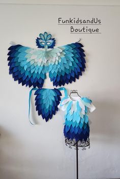 two blue and white paper birds hanging on a wall