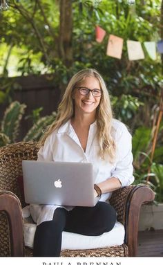 a woman sitting in a chair with a laptop on her lap