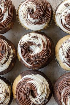 several chocolate cupcakes with white frosting on top