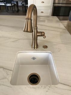 a white sink sitting under a faucet on top of a kitchen countertop