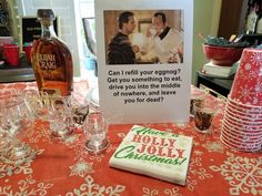 a table topped with lots of glasses next to a bottle of alcohol and a card