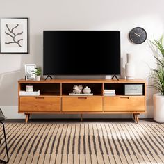 a flat screen tv sitting on top of a wooden entertainment center in a living room