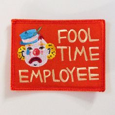 an embroidered patch that says fool time employee with a clown face on the front and bottom