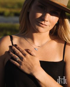 a woman wearing a hat and holding her hands together