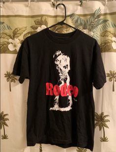 a black t - shirt with the word rodeo on it hanging from a hanger