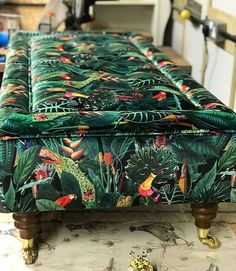 an upholstered footstool with tropical print on it