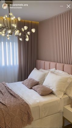 a bedroom with a large bed and a chandelier hanging over the headboard