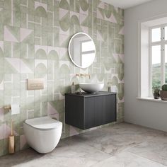 a white toilet sitting next to a bathroom sink under a mirror on top of a wall