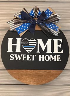 a sign that says home sweet home with an american flag bow on the front of it