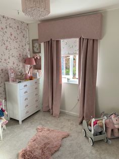 a child's bedroom decorated in pink and white with flowers on the walls, carpeted floor