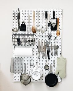 a peg board with various kitchen utensils hanging on it