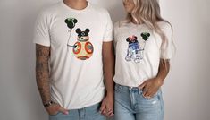 a man and woman standing next to each other wearing t - shirts with cartoon characters on them