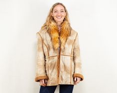 "A faux shearling vintage coat from the 90's. It is crafted from beige faux suede with orange synthetic sherpa lining and trim around the seams. The design features a button closure, two outer pockets, and a luscious sherpa collar.  Vintage condition level: 9/10. *  Model Monta is 5ft (167cm), 123 lbs (56kg ) and she wears the size available. SIZE: Marked size 44, fits like the modern-day size L. To be sure it would fit, please check the measurements below.  FLAT Measurements: Length: 28\" / 71 Afghan Coat, Boho Coat, Winter Overcoat, 90s Shorts, Suede Coat, Vintage Coat, Etsy Fashion, New Vintage, Warm Winter