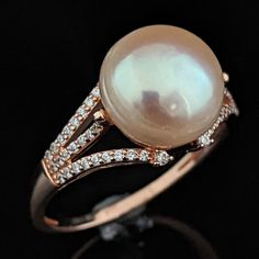 A beautiful preowned travel ring by D'Joy featuring a large pink hued button cultured pearl in sterling silver of matching rose color with clear stone accents Metals: hallmarked sterling silver Markings: D'Joy and 925 Gemstones: pearl - cultured 11.8mm button pearl warm pink hue, clear diamond simulant stones Ring Dimensions: ring top 11.8mm wide (N-S),  10.5mm tall (from the finger), 1.6mm wide base of the shank Ring Size: 11.25 Total Weight: 4.1g Condition: item in fine estate condition SKU: JA4609 Follow us on pinterest.com/sohojewelers/ Instagram @sohojewelers Fine Jewelry Rose Gold Pearl Ring For Formal Events, Rose Gold Pearl Ring For Formal Events, Formal Oval Rose Gold Pearl Ring, Fine Jewelry Rose Gold Pearl Ring For Formal Occasions, Rose Gold Pearl Ring With Gemstone, Formal Rose Gold Pearl Ring Fine Jewelry, Rose Gold Pearl Ring For Formal Occasions, Formal Rose Gold Pearl Ring, Classic Rose Gold Pearl Rings