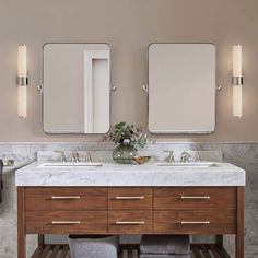 a bathroom with two sinks and mirrors on the wall