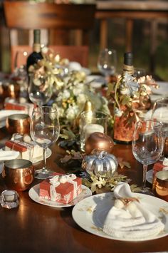 the table is set with plates, silverware and wine glasses for an elegant dinner