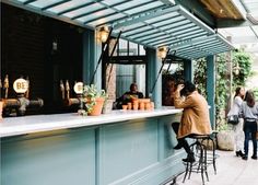 people are standing at the bar waiting for their order