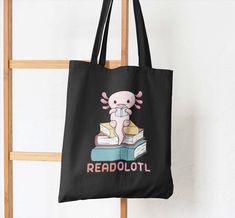 Cute Library Bag with image of an Axolotl saying Read Alotl. They will love having their own custom tote bag to carry home their books from school. This Totebag can be used year after year and won't fall apart like cheap plastic bags which are also not very environmentally safe. Show people you care and don't use single use plastic bags. Can also be used as a beach bag or gym bag if wanted.  100% heavier cotton canvas like material 4 Different sizes to pick from. See sizing image in listing for Cute Library, Reading School, Library Bag, Kids Library, Custom Tote Bags, School Books, School Reading, Medium Tote, Small Tote