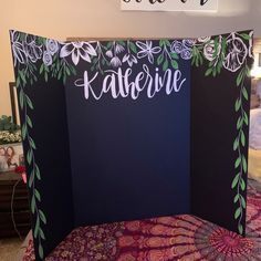 a black and white photo booth with flowers on the sides, name kateine written in cursive writing