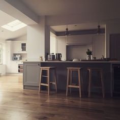 an open kitchen and living room with hardwood floors