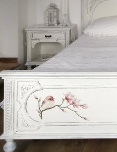 a white bed with pink flowers painted on it