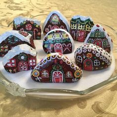 a glass plate topped with lots of small houses covered in frosted icing on top of a table