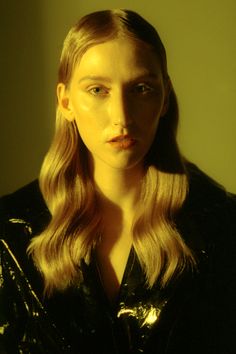 a woman with long blonde hair wearing a black jacket