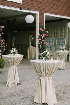 the tables are covered with white tablecloths and flower centerpieces on them