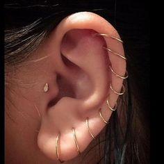 a close up of a person's ear with three different types of piercings