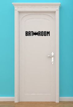 an open door with the word bathroom on it in front of a blue wall and wooden floor