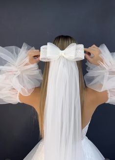 the back of a woman's head wearing a veil and white dress