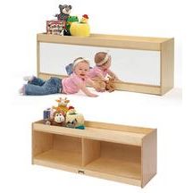 two children's toys sitting on the floor in front of a wall mounted mirror