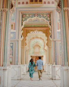 a man and woman are walking through an ornate building