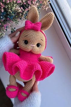 a crocheted stuffed animal with a pink dress