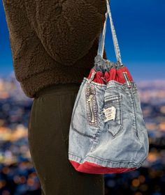 a woman holding a purse with her back to the camera, in front of a cityscape