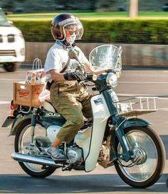 a man riding on the back of a motorcycle down a street