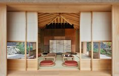 the inside of a japanese style room with two red chairs and an open door leading to another room