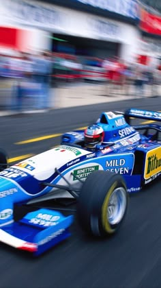 a blue race car driving down a track