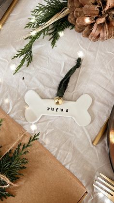 a dog bone ornament on a table with pine cones and other holiday decorations