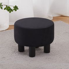 a black ottoman sitting on top of a rug