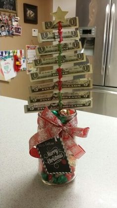 a christmas tree made out of money sitting in a jar on top of a counter