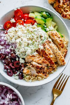 a white bowl filled with meat, rice and veggies next to a fork