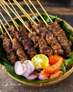 skewered meat and vegetables in a basket on a table