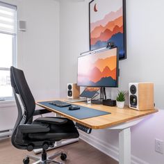 a desk with a computer and speakers on it