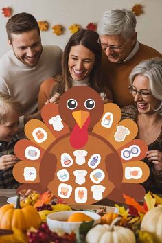 a family holding up a turkey cutout in front of a table full of thanksgiving decorations