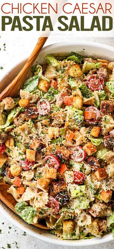 chicken caesar pasta salad in a white bowl with wooden spoons and parsley on the side